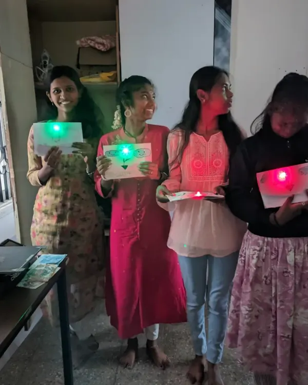 Young makers proudly displaying their finished paper circuit projects. This is what it's all about for us: that moment of excitement when you create something that lights up.