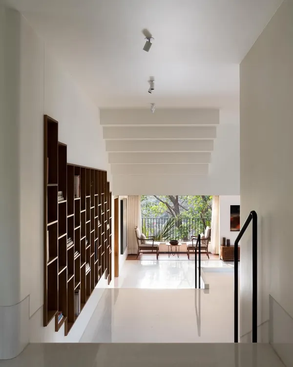 This view captures the essence of the Multilevel House, where staggered floors, a custom bookcase, and a large window framing the trees create a dynamic yet peaceful living environment. It shows how I use architecture to shape experience.