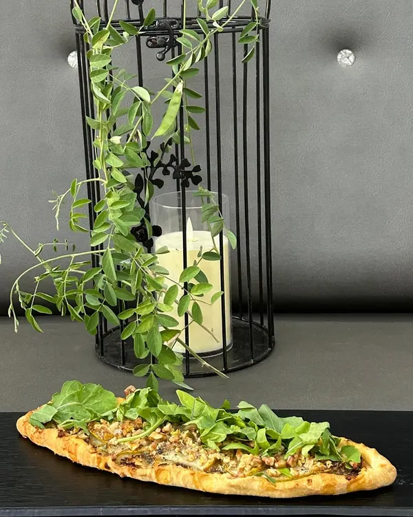 Our Pear & Blue Cheese Flatbread is a sophisticated choice, balancing sweet and savory flavors on a crispy base, topped with fresh arugula.