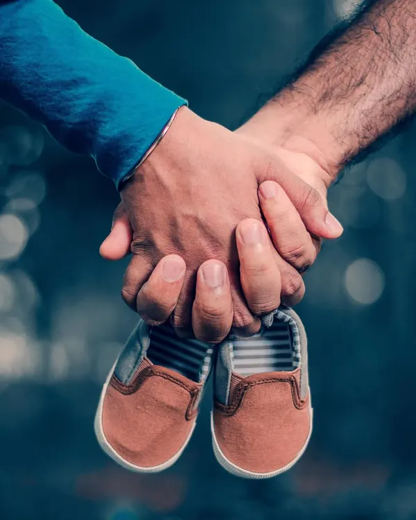 (Hero Media) This is what it's all about: the connection and anticipation. I focus on meaningful details, like this shot of parents' hands holding a tiny pair of baby shoes, symbolizing the new life they are waiting to welcome.