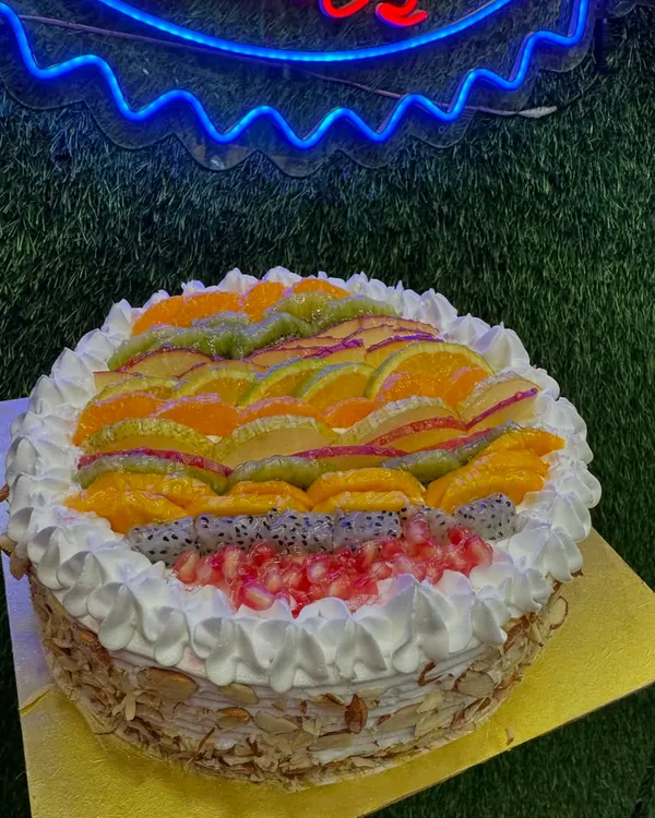 Our Mix Fruit cake is a refreshing and light option, loaded with a variety of fresh fruits like oranges, kiwi, pomegranate, and dragon fruit. The sides are coated with crunchy almonds for a perfect texture contrast.