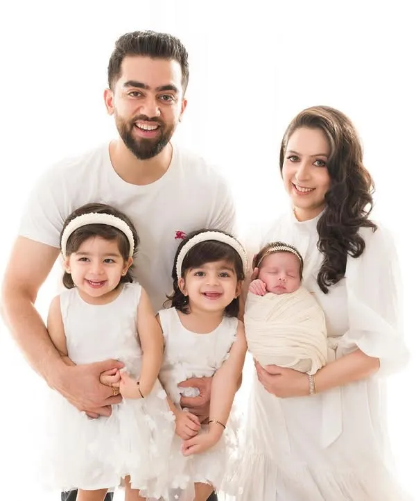 A beautiful family of five. This portrait captures the joy and love as they welcome their newest little princess, surrounded by her adoring big sisters. A perfect family photograph to mark a new chapter.