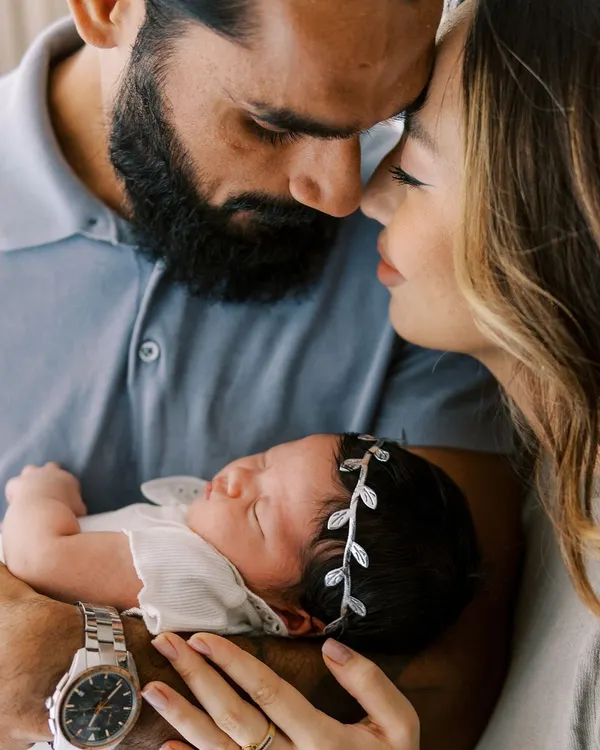 The world fades away in these moments. A new mother and father cherishing their sleeping newborn, a perfect example of an intimate, lifestyle newborn session at home.