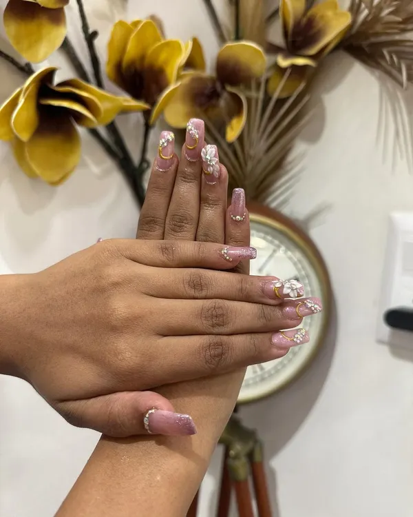 Your hands are always on display, especially during wedding festivities. We offer custom bridal nail extensions and art, like this beautiful set featuring delicate 3D flowers, glitter, and gold accents to perfectly match your bridal ensemble.