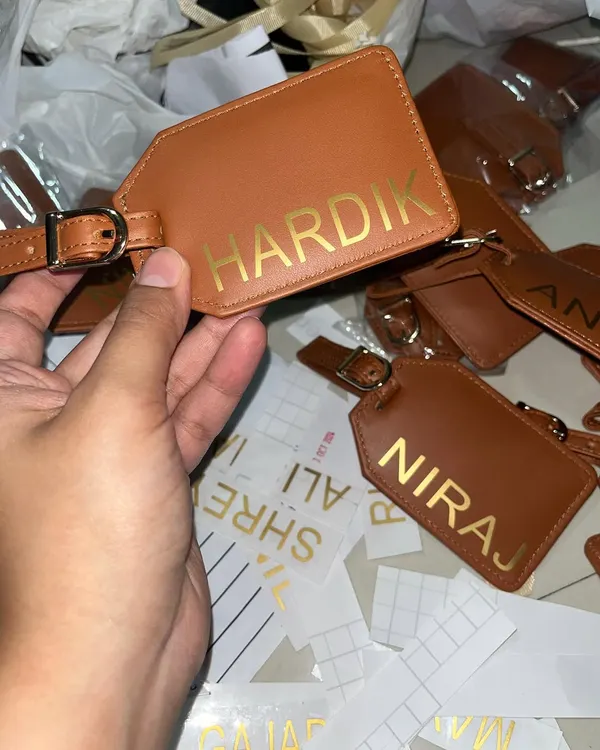 A behind-the-scenes look at personalizing leather luggage tags with gold foil for a large corporate order. Every name is applied with care.