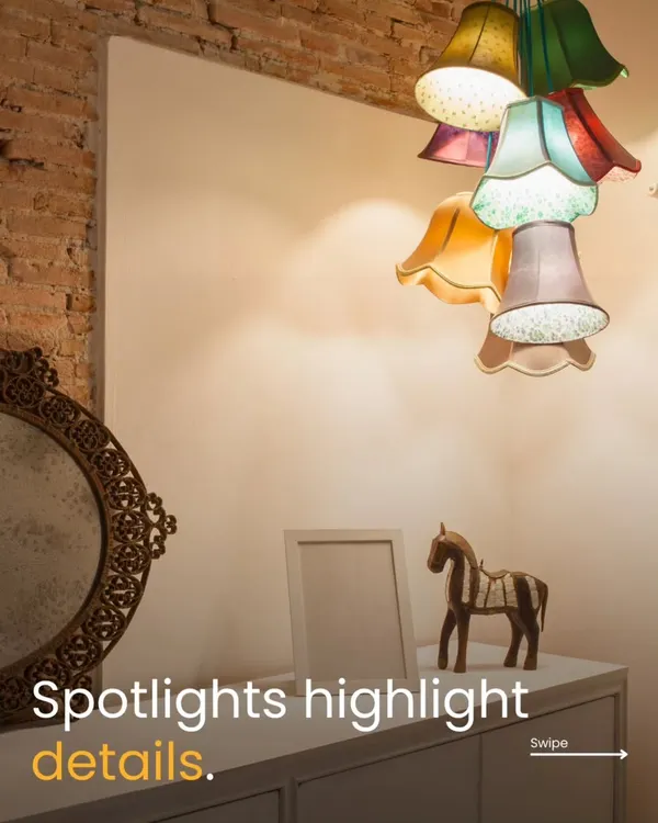 Lighting is the soul of interior design. In this image, the quirky, multi-colored pendant light acts as a statement piece, while spotlights are used to highlight the decor on the console table, creating layers of light.