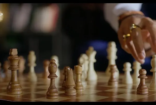A detail shot from the Sankalp Group campaign with Ronit Roy. The focus on his hand moving a chess piece, adorned with a statement ring, adds to the character's sophisticated and strategic persona.