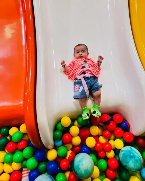 Even our tiniest visitors can enjoy the fun. This little one is having a safe and gentle slide into our colorful ball pit.