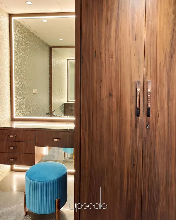 This dressing room combines the warmth of natural wood with the richness of Grigio Italian marble flooring. We focused on creating a functional yet luxurious personal space, using an illuminated mirror and a pop of color with the teal stool to add character and visual interest.