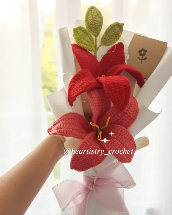 A beautiful bouquet featuring two vibrant red crochet lilies. The details in the petals and the bright yellow stamen make these flowers really stand out.