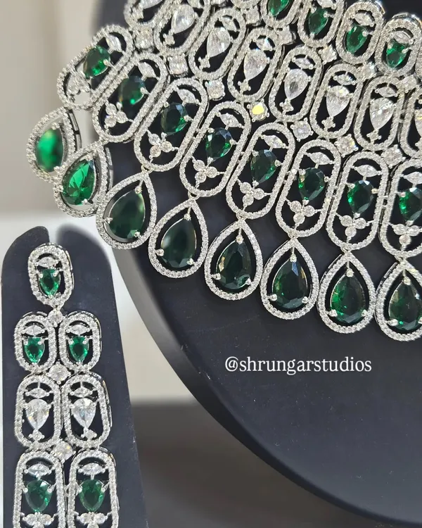 A close-up view of our silver-plated AD necklace with emerald-green teardrop stones, showing the fine craftsmanship and sparkle.
