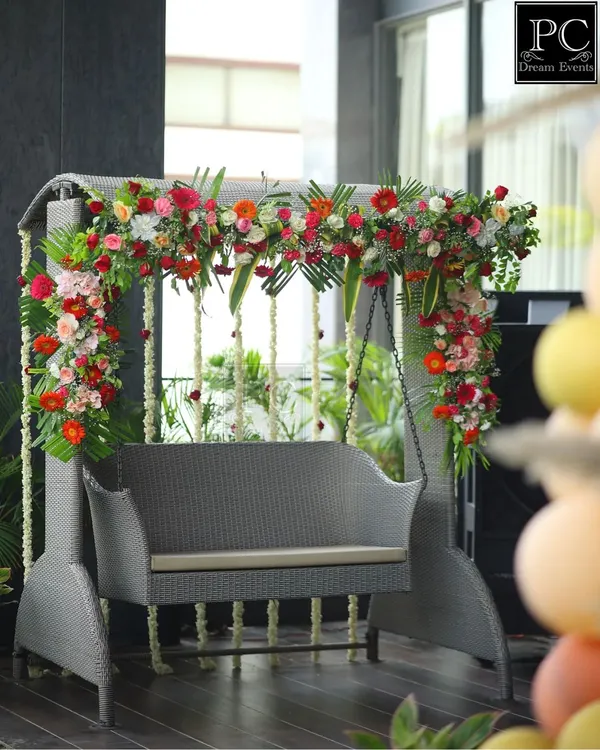 A beautiful floral swing I decorated for a baby shower. The mix of red, pink, and orange flowers with hanging jasmine strings created a perfect, fragrant spot for the mom-to-be.
