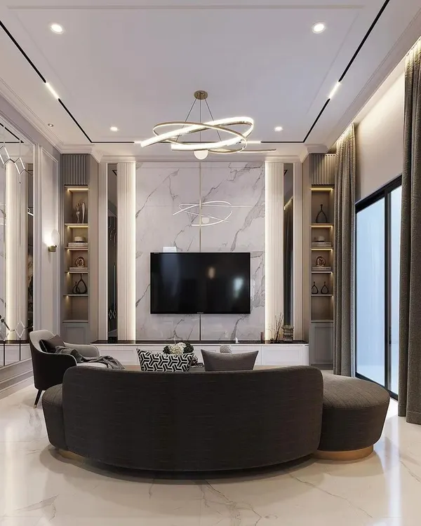 We designed this living room as the heart of the home, combining luxury and comfort. The marble-finish feature wall, modern chandelier, and curved sofa create an inviting space for relaxation and entertainment, showcasing our approach to creating high-end residential interiors.