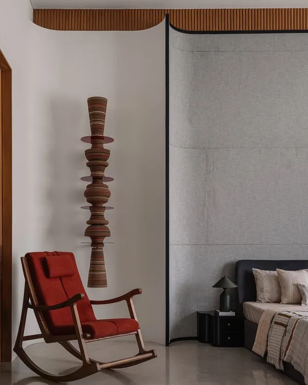 A comfortable rocking chair from Magari sits beside our custom 'Astral' wall totem, creating a quiet corner for reflection. The totem's stacked, turned-wood forms add a vertical, sculptural element that contrasts beautifully with the chair's classic lines.