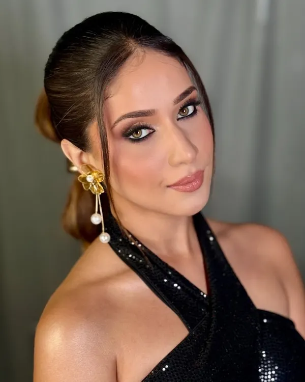 A stunning glam look perfect for a cocktail party or reception. This features a dramatic smokey eye with a pop of white liner, beautifully sculpted cheeks, and a glossy nude lip.