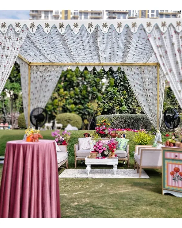 A beautiful lounge area created under a custom-printed tent. We paired comfortable sofas with colorful, hand-painted furniture and fresh flowers to create an inviting space for guests to relax.