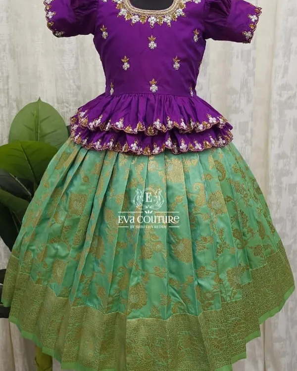A beautiful tiered peplum lehenga in purple and sea green. The blouse is heavily embroidered, and the skirt is a rich Banarasi brocade.