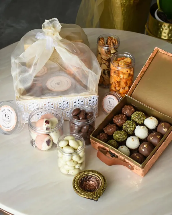 This is what a celebration looks like in a box. My custom Diwali hampers are designed to be a complete experience, featuring an assortment of my signature chocolate truffles, jars of savory and sweet nuts, and a traditional diya to light up the festivities.
