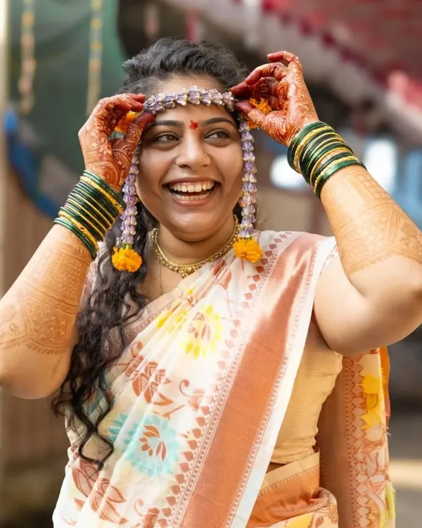 This is the moment of pure happiness. I love capturing the bride as she places the mundavalya on her head during the haldi ceremony, a beautiful Maharashtrian wedding tradition. Her smile here is so genuine and full of excitement for what's to come.