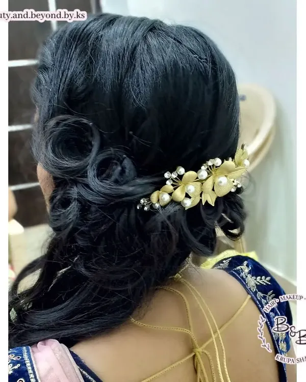 Curls are always a great choice for a reception. For this bride, I created classic side-swept curls with beautiful detailing at the back, secured with a stunning gold and pearl hair brooch for a truly bridal feel.