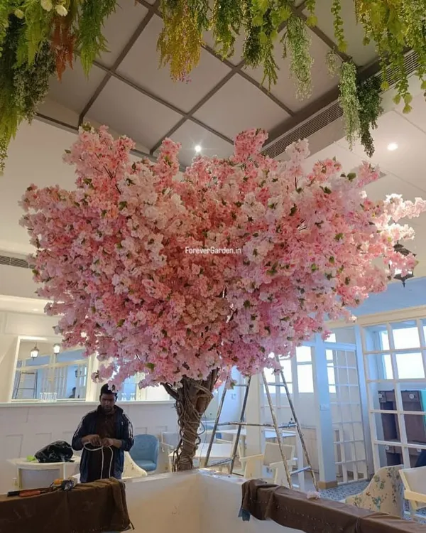 This vibrant, custom-made pink blossom tree creates an unforgettable focal point in a commercial space, perfect for cafes and event venues.