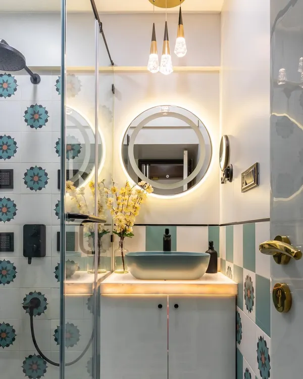 A close-up of the stunning floral-patterned tiles and backlit mirror in this bathroom. The combination of modern lighting and traditional motifs creates a unique and elevated design.