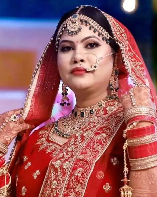 The quintessential Indian bride. This portrait captures the complete look, from the intricate matha patti and nath to the bold lip color, all designed to create a regal and memorable appearance.