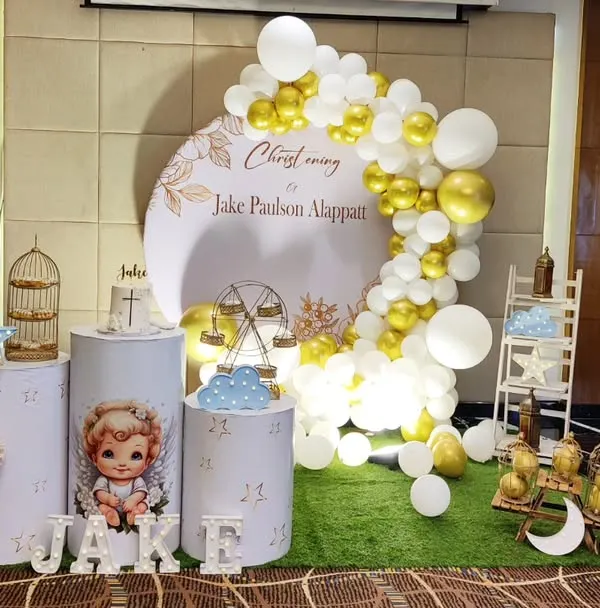 An elegant Christening celebration for baby Jake. The white and gold theme features a custom backdrop, delicate props like a birdcage and ferris wheel, and beautiful balloon columns.