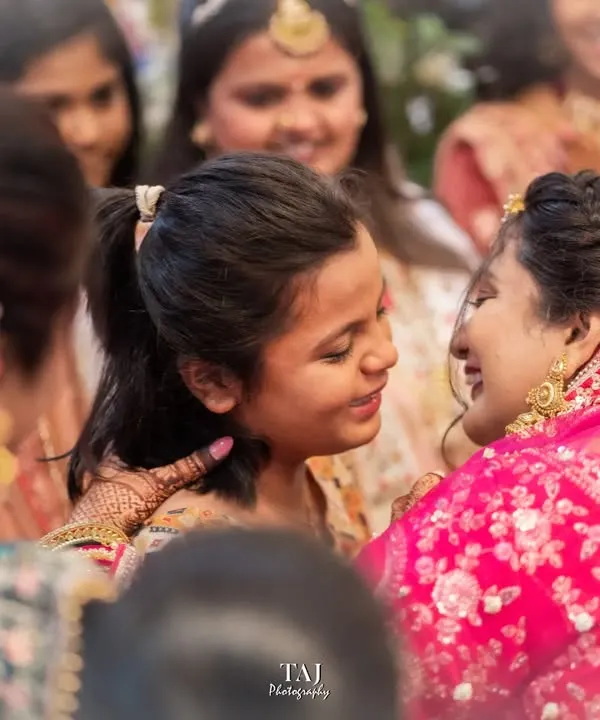 A tender moment between the bride and a younger family member during the Bidai. These are the emotional, unscripted goodbyes that are so important to capture.