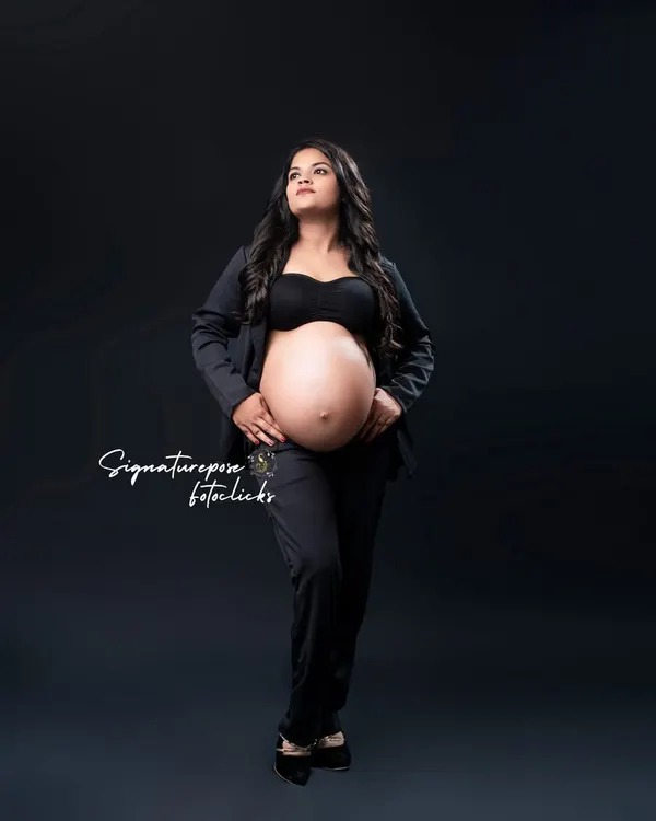 A powerful, full-length portrait in a black pantsuit. This look is all about celebrating the strength and confidence of motherhood.