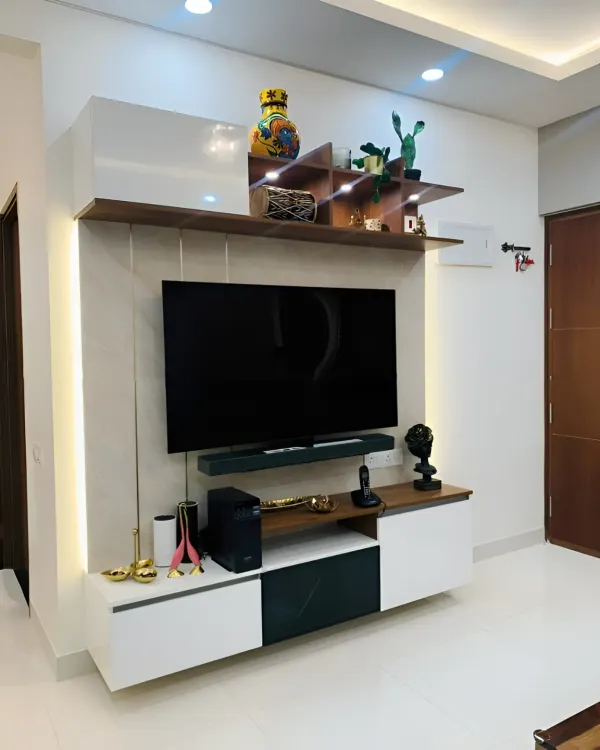 This modern TV unit features a high-gloss white finish paired with dark wood accents. The asymmetrical shelving adds visual interest, while vertical side lighting enhances the contemporary look.