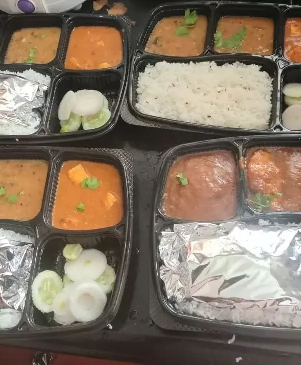 A look at our popular North Indian vegetarian thali, perfect for parties and corporate events. Each packed meal box contains steamed rice, soft rotis wrapped in foil, dal, a paneer curry, fresh salad, and pickles, ensuring a complete and satisfying meal for your guests.