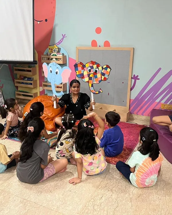 This is what pure engagement looks like. During our interactive story time, I use puppets and expressions to bring tales like 'Elmer the Elephant' to life, helping children develop a love for stories and listening skills.