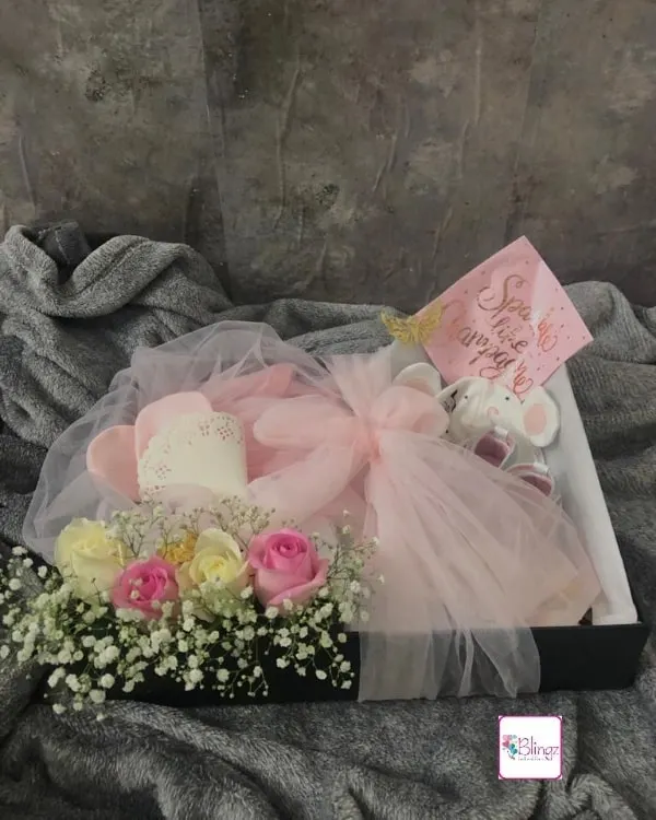 It was a true pleasure to create this luxury newborn hamper to welcome a precious baby girl. This bespoke gift box features fresh roses and baby's breath, a soft elephant toy, and practical baby essentials, all wrapped in delicate pink tulle for an elegant presentation.