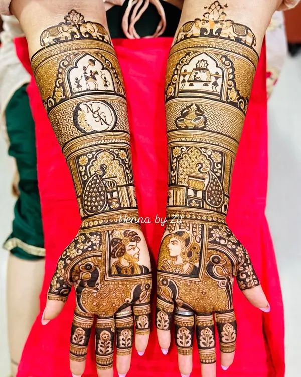 A complete bridal story. This design features beautiful Raja-Rani portraits on the palms, couple initials, and traditional motifs like peacocks and elephants, telling a full love story on the bride's hands.