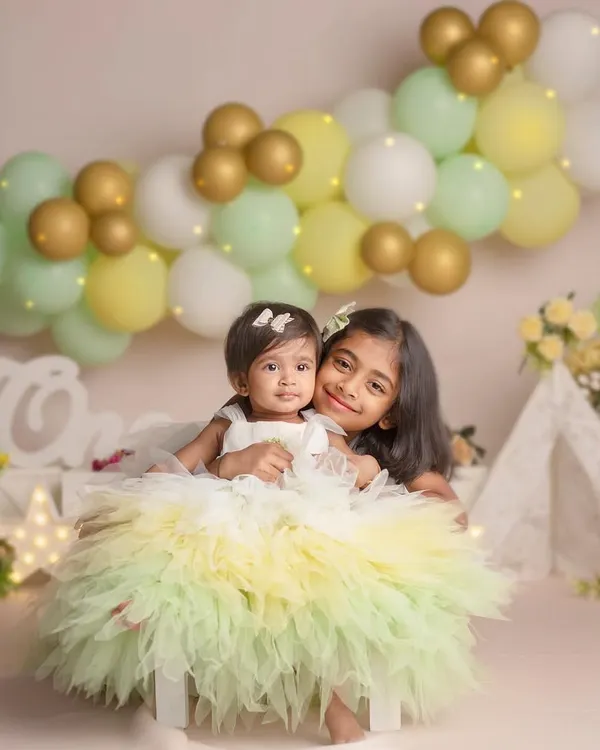 Sisters for life and beyond! This beautiful portrait of two sisters in matching dresses captures the sweet and playful bond they share.