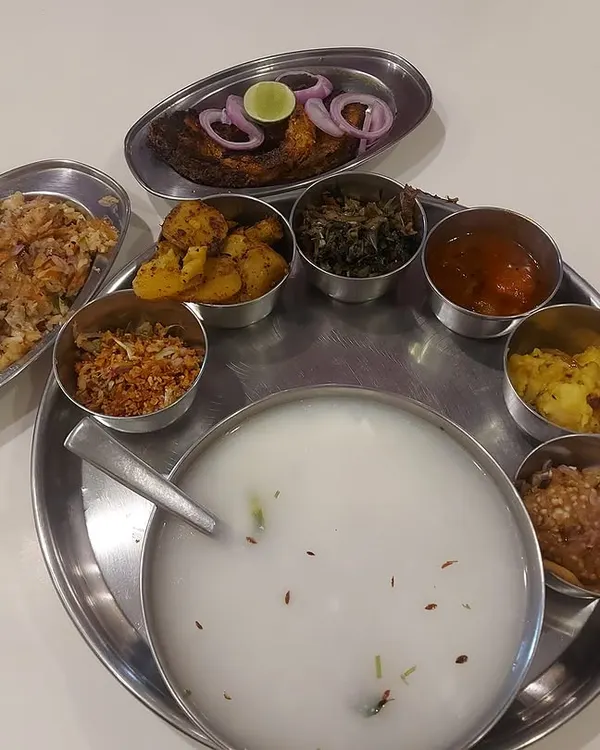 A glimpse into the heart of Odia tradition, our authentic Pakhala Thali. This celebratory meal features fermented rice served with an array of accompaniments like fried fish, various bhajas (fries), and salads, offering a truly soulful dining experience.