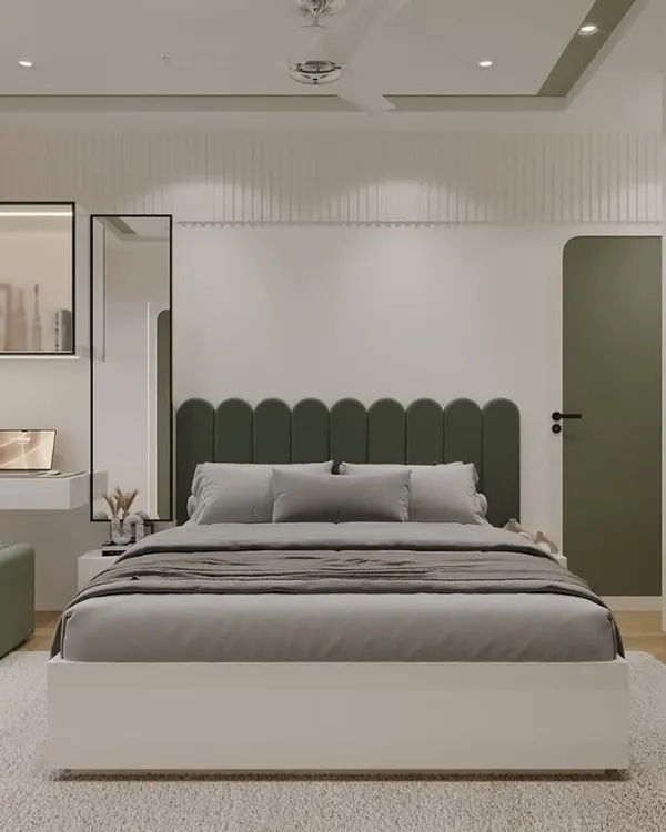 This is a full view of the olive-green bedroom, showing how all the elements come together. The scalloped headboard, matching ottoman, and custom wardrobes with rounded panels create a cohesive and calming design, complemented by a practical window seat and study nook.