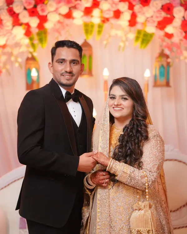 An elegant portrait of the couple at their wedding reception. The groom in his classic tuxedo and the bride in her shimmering gown look ready to celebrate their new beginning.