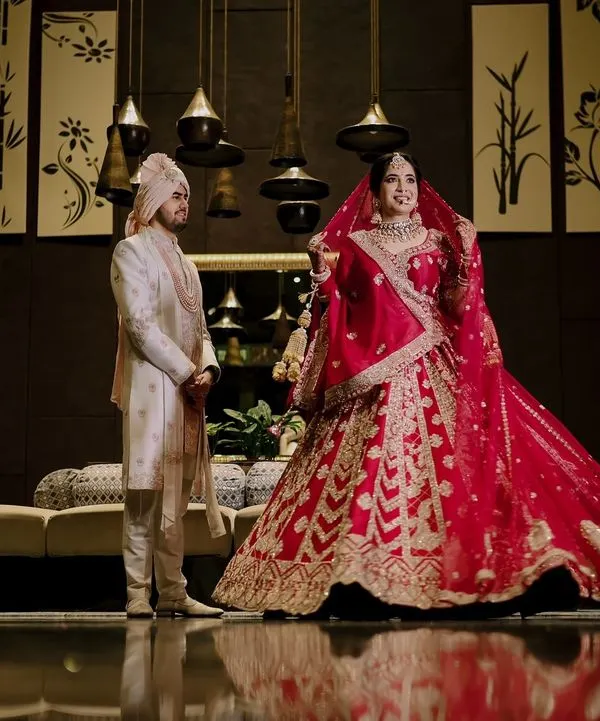 A stunning full-length portrait of Ritish and Aastha on their wedding day in Delhi, capturing the grandeur of their attire and the elegance of the moment.