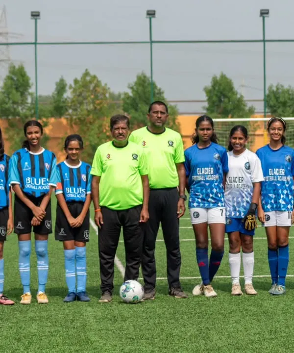 Our U13 girls' squad stands with their coaches, ready to learn and grow. We focus on building a strong foundation for their football careers.