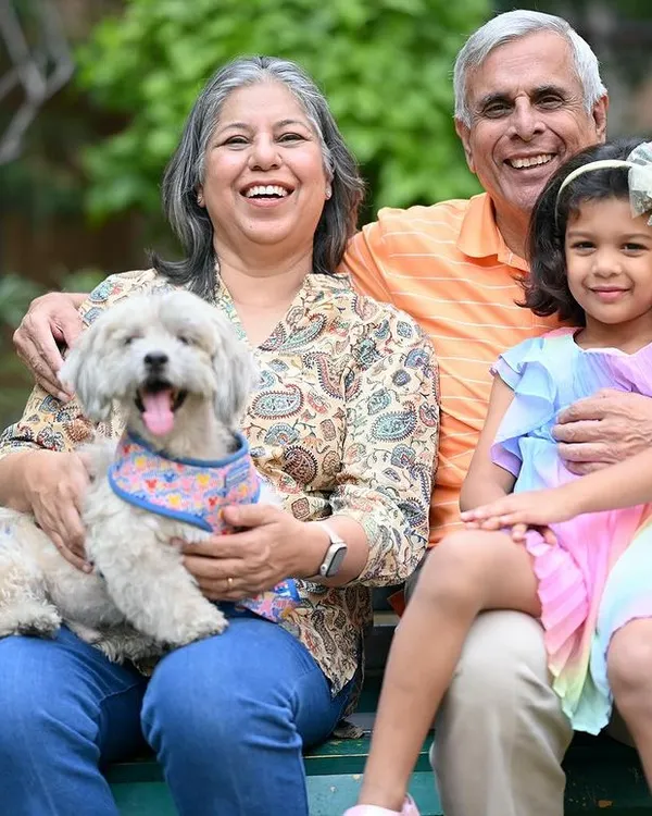 A beautiful moment of pure joy shared between grandparents, their grandchild, and their furry family member during a relaxed outdoor session in a Gurgaon park.