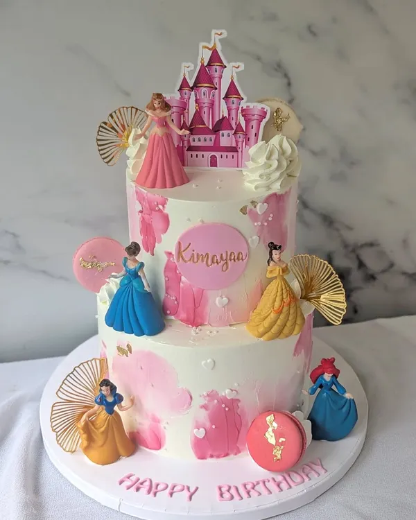 Every princess deserves a castle. This royal two-tier treat for a little princess features a castle topper and several Disney princesses, decorated with pink watercolor buttercream.