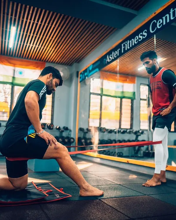 I believe in a hands-on approach. Here, I'm working with cricketer Rinku Singh on a resistance band drill to improve hip mobility and strength, a key aspect of generating power for batting and preventing lower-body injuries.
