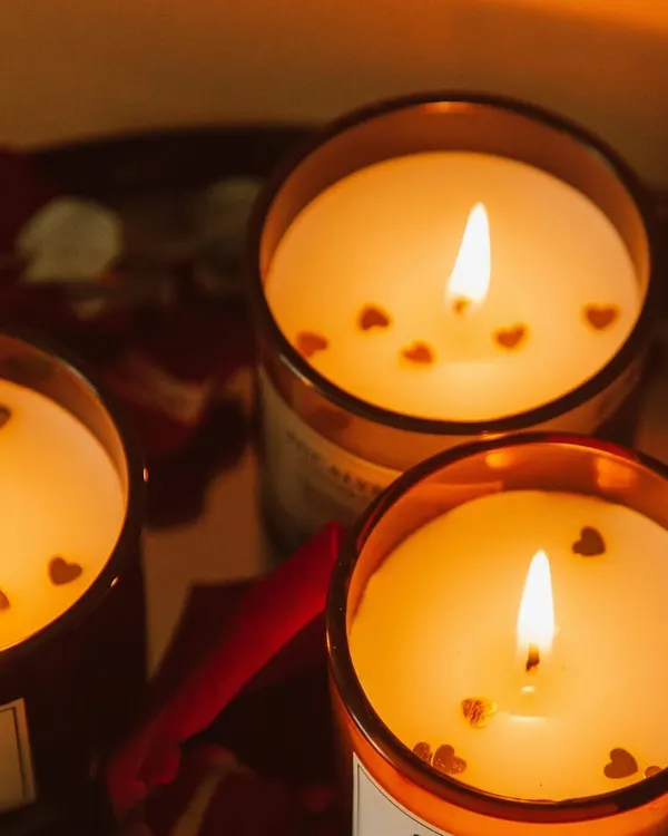 Set a warm, romantic mood with my special occasion candles. Pictured here are three of my scented jar candles, lit to show their beautiful glow, with tiny hearts floating on the melted soy wax. These are a customer favorite for Valentine's Day and anniversaries.