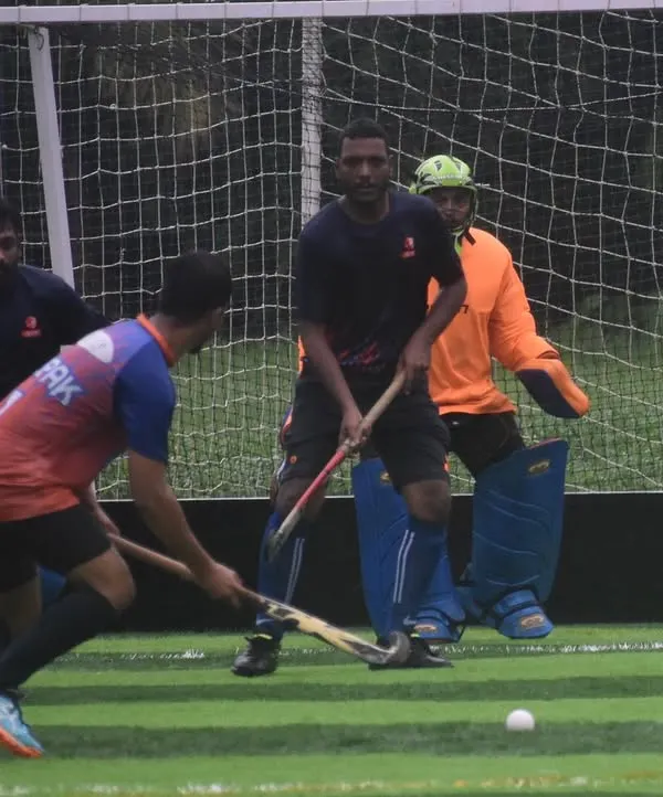An attacker prepares to take a shot while the goalkeeper holds his position. This drill focuses on the duel between shooter and keeper, a critical moment in any hockey match.