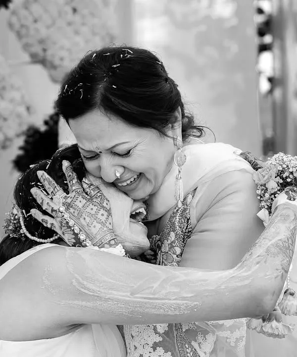 A daughter's emotional embrace with her mother during a Haldi ceremony. This black and white photo freezes a moment of pure, unfiltered love and connection between generations.