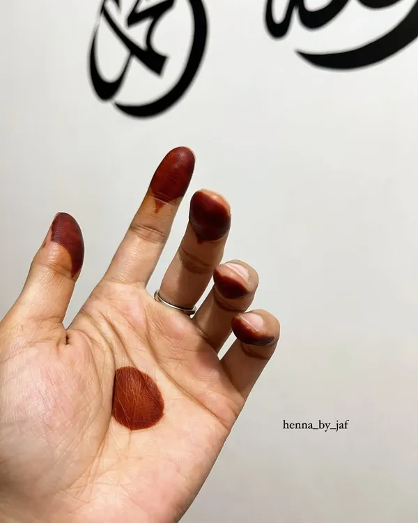 The beautiful, simple stain of henna on the fingertips and a circle on the palm, a very traditional and classic look.