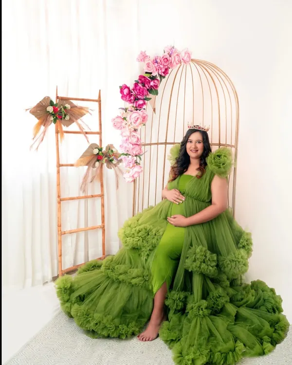 A true queen moment. This magnificent green tulle gown and floral birdcage setup create a portrait that is nothing short of magical.