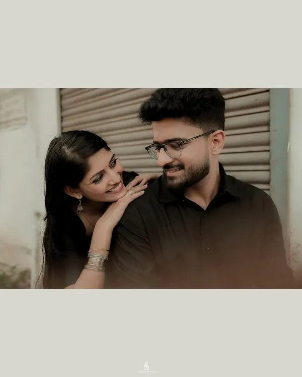 An intimate close-up in an urban setting. The soft, moody lighting creates a cinematic feel, focusing entirely on the couple's connection.